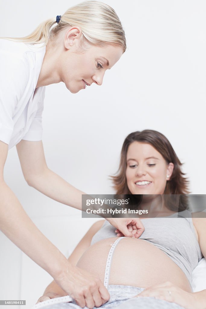Médico examinar embarazada womans de vientre