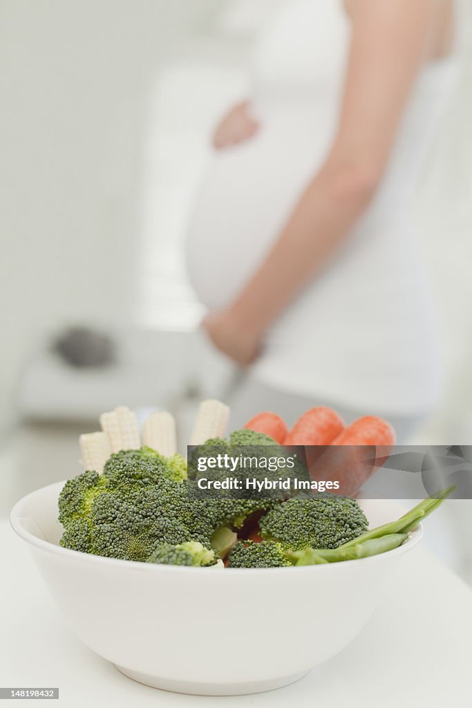 Pregnant woman with bowl of vegetables