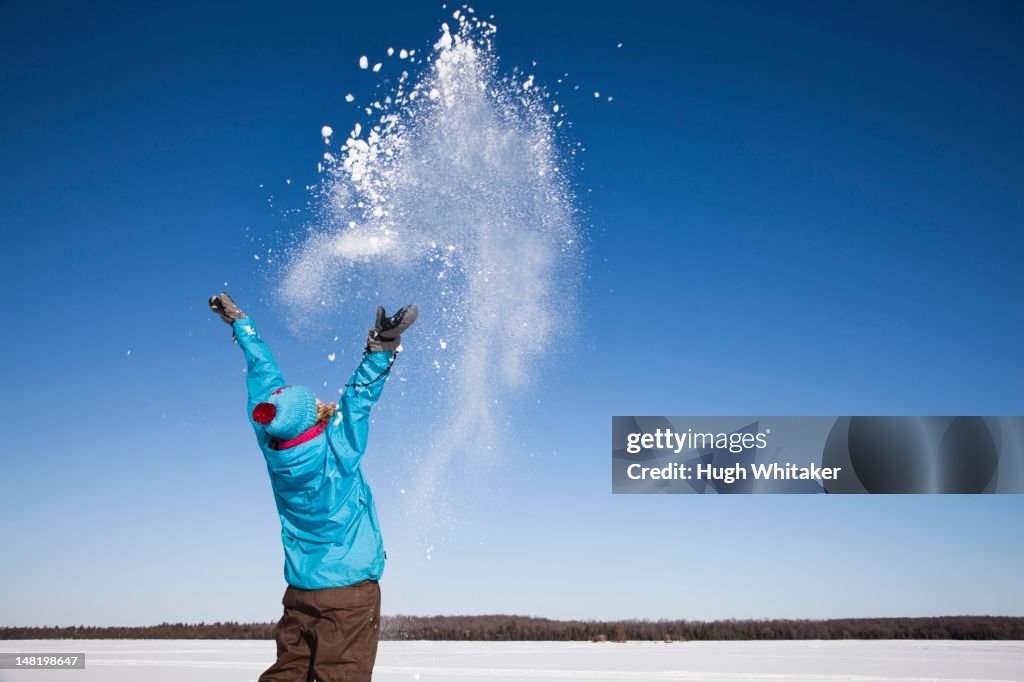 Woman playing with snow outdoors