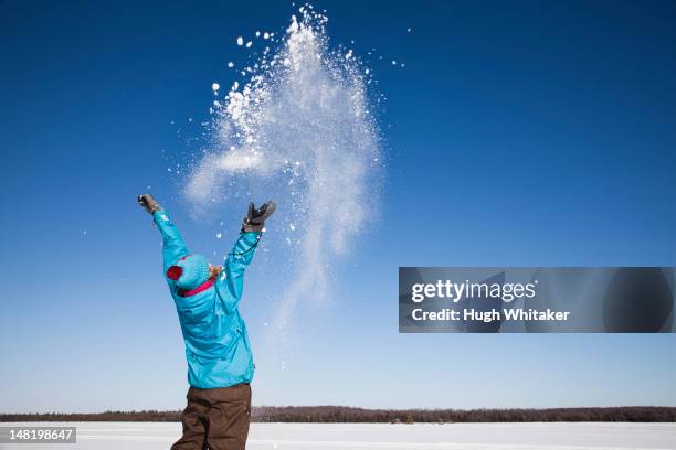woman playing with snow outdoors - schneeball stock-fotos und bilder