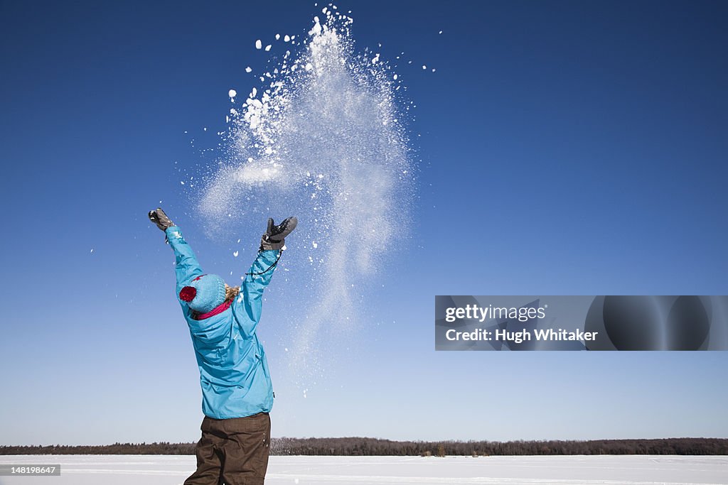 Woman playing with snow outdoors