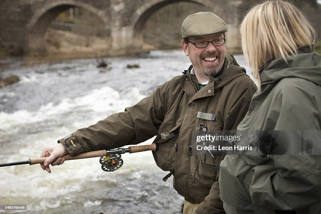 Pareja la pesca de salmón en río