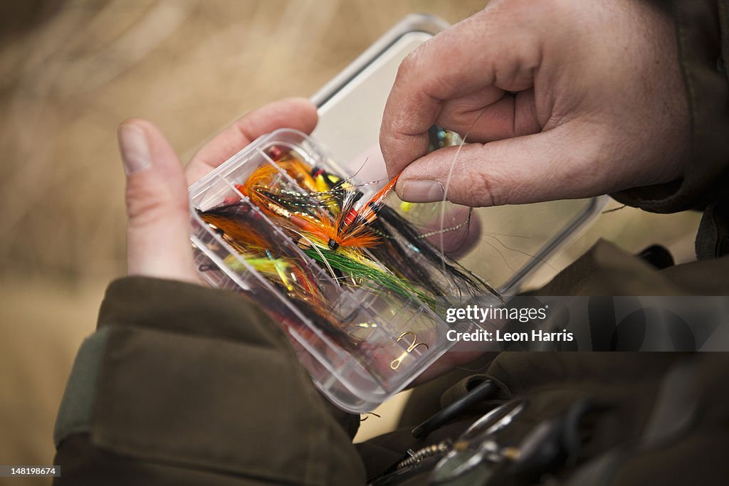 Man pulling fishing tackle from box