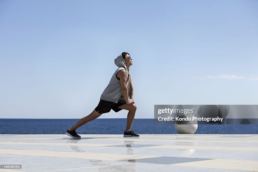 若い男性のストレッチ海の近く