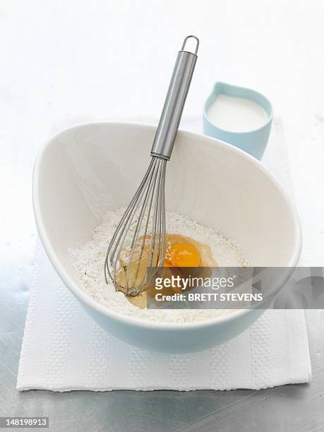 whisk in bowl with eggs and flour - schneebesen stock-fotos und bilder