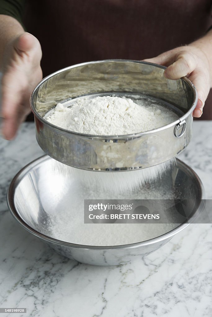 Chef sifting flour in bowl