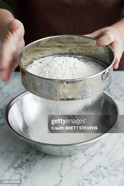 chef sifting flour in bowl - sifting stock pictures, royalty-free photos & images