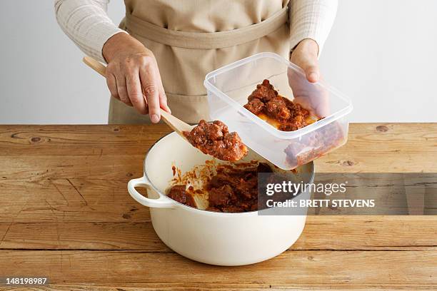 woman spooning meat into tupperware - frozen food fotografías e imágenes de stock