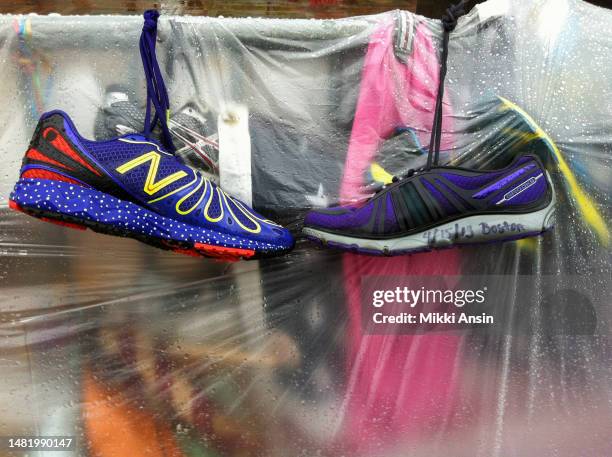 Close-up of running shoes hanging on a plastic-covered memorial to victims of the Boston Marathon Bombing , Copley Square, Boston, Massachusetts, May...