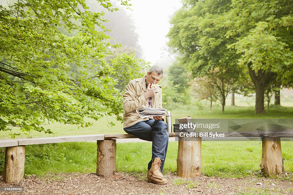 Mann liest Zeitung im park