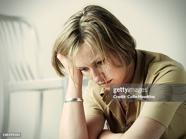 anxious woman resting head in hand - hålla huvudet i händerna bildbanksfoton och bilder