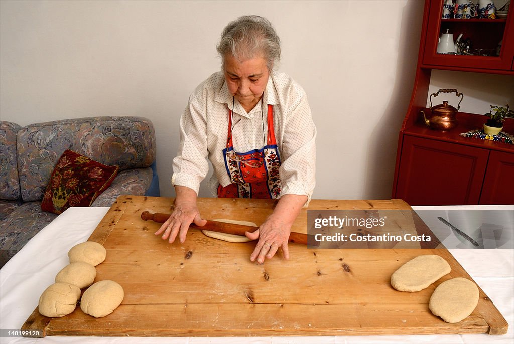 Older woman rolling dough on board
