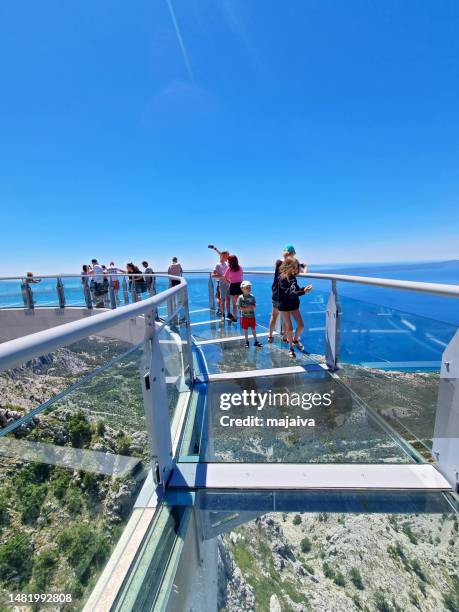 tourist walking and looking on the skywalk biokovo. in distance adriatic sea and town of makarska, croatia - makarska imagens e fotografias de stock