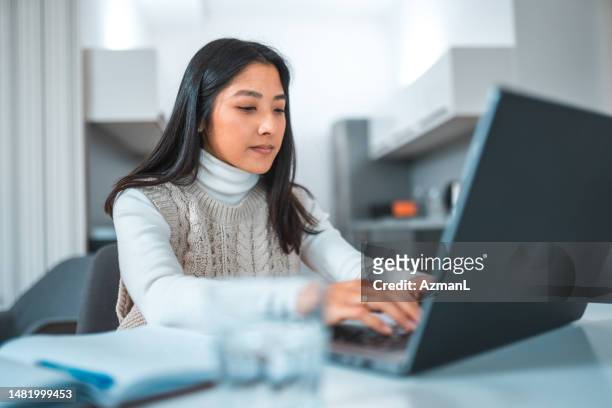 young asian female using a computer to work from home - multiple choice stock pictures, royalty-free photos & images