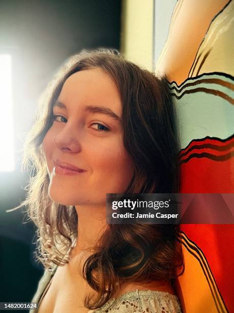 beautiful gay and autistic teen girl, proudly celebrating herself, standing in front of a homemade painting in her home. - autismus stock pictures, royalty-free photos & images