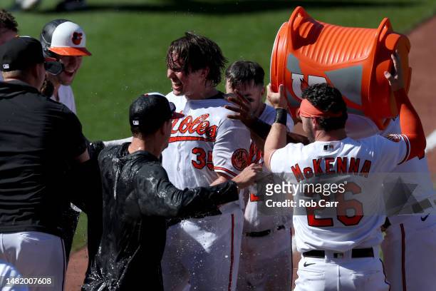 Adley Rutschman of the Baltimore Orioles celebrates with teammates after hitting a ninth inning walk off home run to the give the Orioles an 8-7 win...