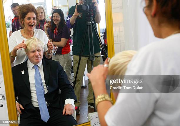 Boris Johnson meets hair stylist during the opening of the P&G Salon at the Olympic Village on July 12, 2012 in London, England.
