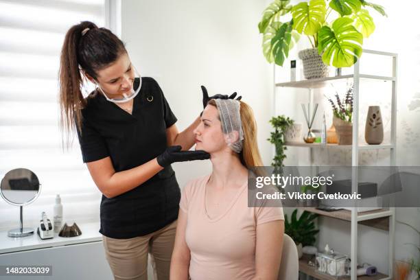 cosmetologist preparing patient for facial treatments - dermatologists talking to each other patient stock pictures, royalty-free photos & images