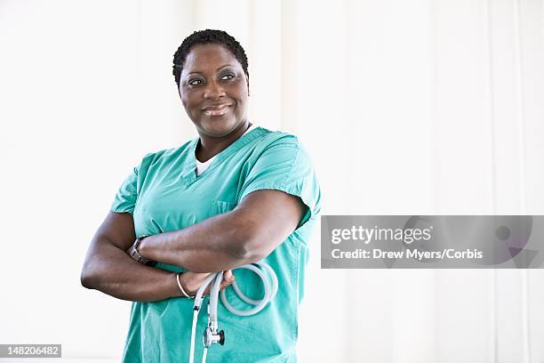 portrait of smiling female nurse in hospital - portrait white background looking away stockfoto's en -beelden