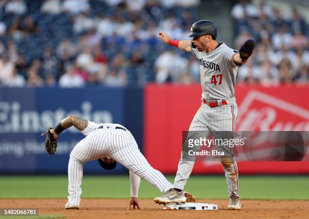 Edouard Julien of the Minnesota Twins signals that he is safe at second base as Gleyber Torres of the New York Yankees is unable to make the play in...