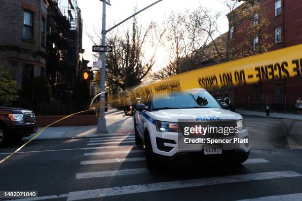 New York City police gather at the scene of a shooting of a 78-year-old man by police on April 13, 2023 in the Bedford-Stuyvesant neighborhood of the...