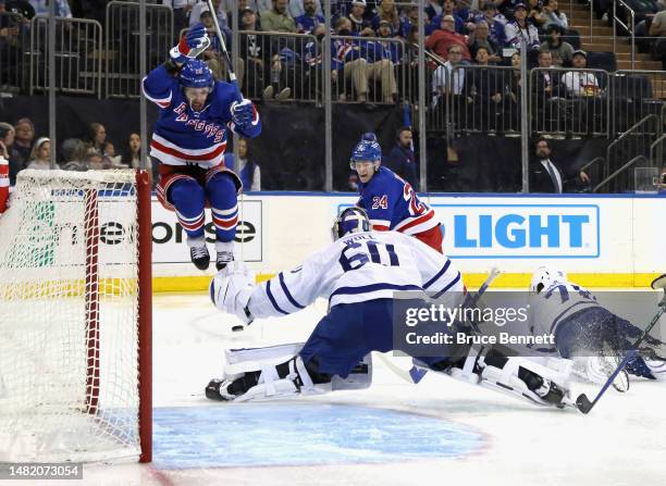 Kaapo Kakko of the New York Rangers scores a second period goal against Joseph Woll of the Toronto Maple Leafs as he is screened by Artemi Panarin at...