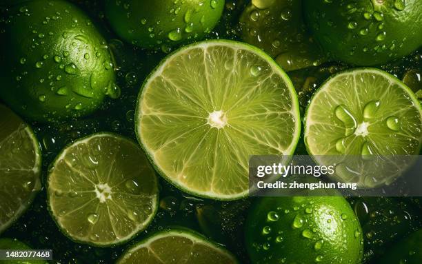 sliced limes showered with water - freshness photos et images de collection