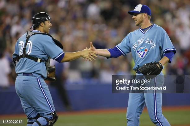 Roy Halladay of the Toronto Blue Jays celebrates a complete-game victory with Rod Barajas against the New York Yankees during MLB game action at the...
