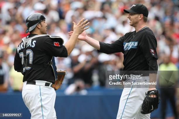 Roy Halladay of the Toronto Blue Jays celebrates a complete-game victory with Rod Barajas against the Boston Red Sox during MLB game action at the...