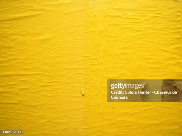 crumpled yellow paper stuck on a wall in paris, france - sticker stock pictures, royalty-free photos & images