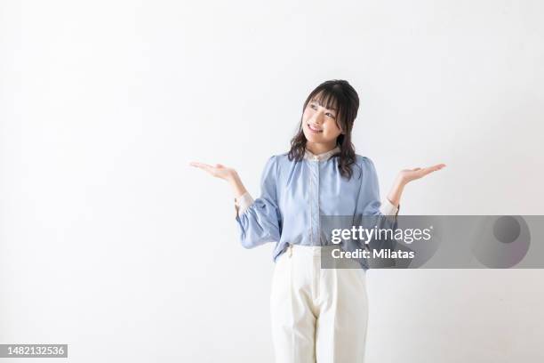 a woman thinking with her arms outstretched - japanese greeting stock pictures, royalty-free photos & images