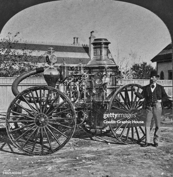 Man standing beside a steam fire engine, possibly a Silsby Steam Pumper, in Foxborough, Massachusetts, circa 1885. The image is one half of a...