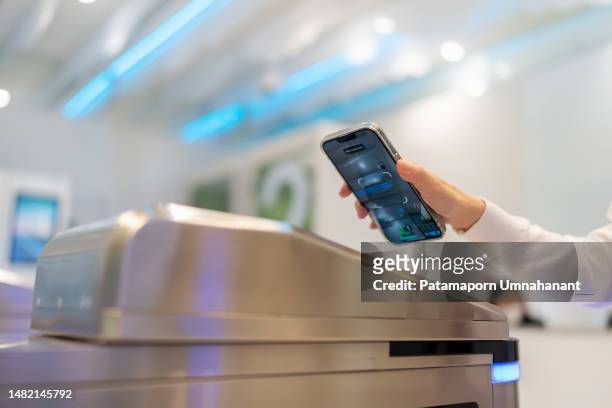 digital access technology is convenient and highly secure. close up hand of asia businesswoman using smartphone scan barcode at the gate to unlock the door to enter the modern co working space. - entering turnstile stock pictures, royalty-free photos & images