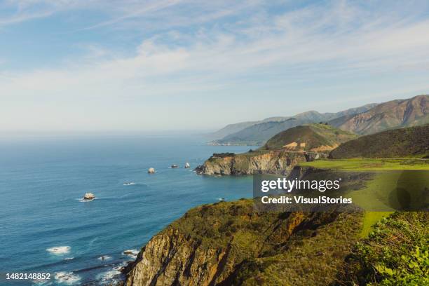 blick auf die malerische felsige küste während eines sonnigen tages in big sur, kalifornien - cliff shore stock-fotos und bilder