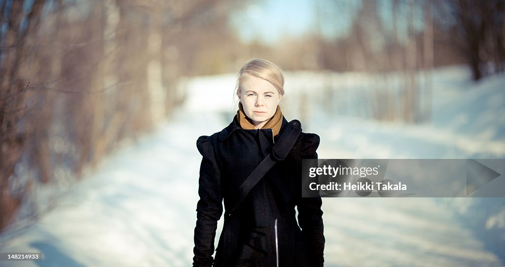 Portrait of young woman in snow path