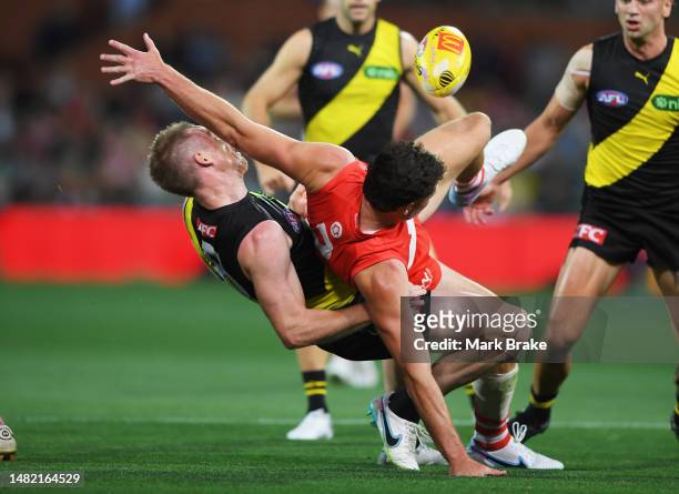 Jack Riewoldt of the Tigers is hit by Hayden McLean of the Swans in a marking contest during the round five AFL match between Sydney Swans and...