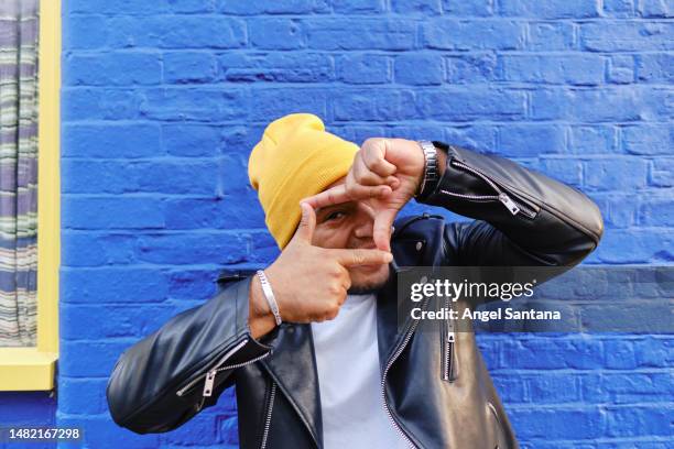 man making finger frame in front of blue brick wall - modern living bricks stock pictures, royalty-free photos & images