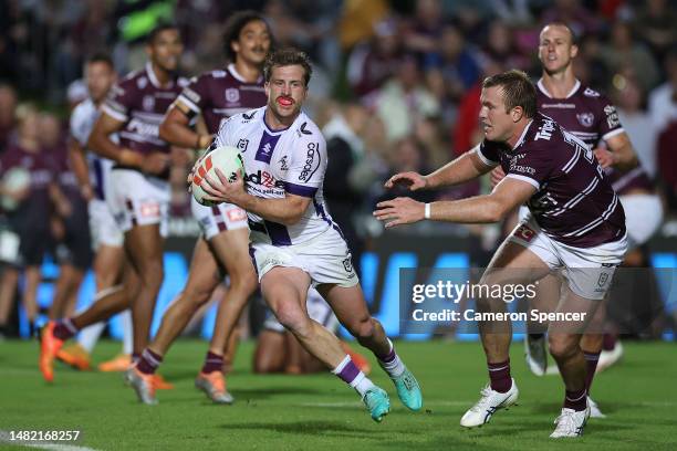 Cameron Munster of the Storm is tackled during the round seven NRL match between the Manly Sea Eagles and Melbourne Storm at 4 Pines Park on April...