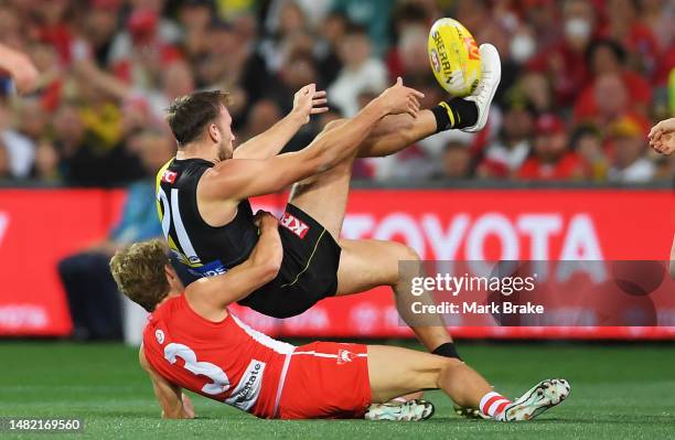 Noah Balta of the Tigers kicks tackled by Dylan Stephens of the Swans during the round five AFL match between Sydney Swans and Richmond Tigers at...