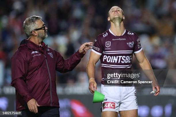 Daly Cherry-Evans of the Sea Eagles is attended to by a trainer after a late tackle by Tui Kamikamica of the Storm during the round seven NRL match...