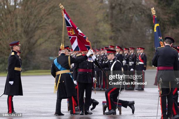 King Charles III honours the new 'colours' on his flag displaying his cypher during the inspection of the 200th Sovereign's parade at Royal Military...