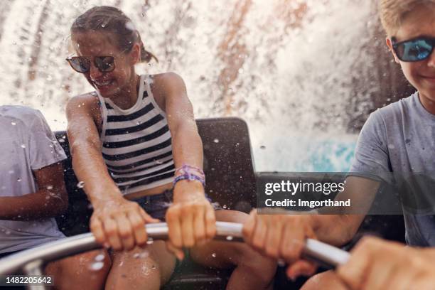 teenagers enjoying river rapids ride in amusement park - amusementsparkritje stockfoto's en -beelden