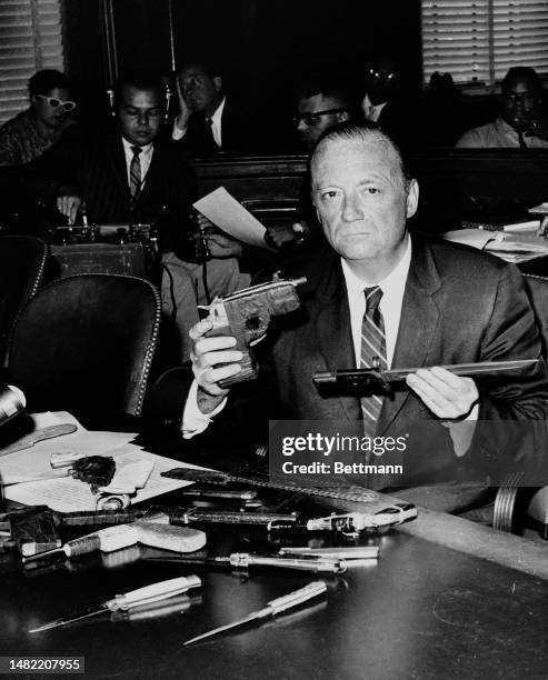 New York State Supreme Court Justice John E Cone displays confiscated weapons including knives and guns as he appears before a Senate Subcommittee on...