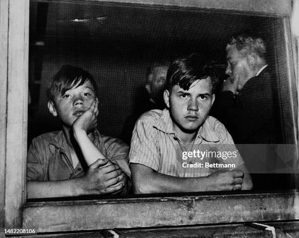 Brothers Charles and Robert Munday look through the window of Chicago's county morgue during the inquest into the death of Thomas Laux, aged 3, July...