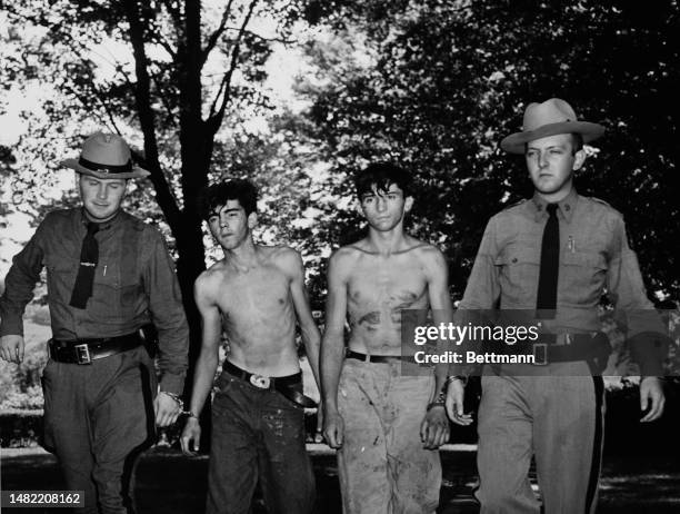 State troopers named as John Dooley and Robert Burke are shown leading David Cotter and James Waddington to the Brewster State police barracks for...