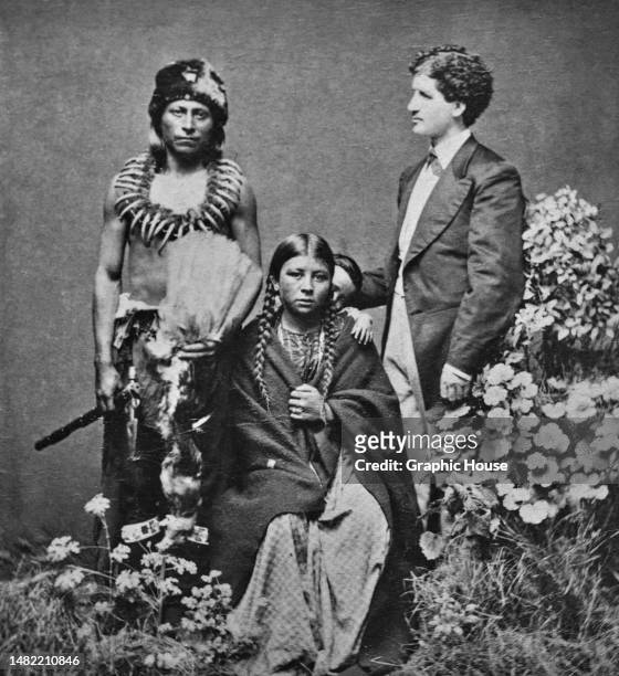 Sioux Chief Iron Bull, a Native American woman and Iron Bull's son, peeking out from behind the woman, and German interpreter Julius Meyer in a...