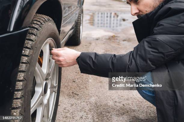 man checking status of car's tires - check stock pictures, royalty-free photos & images