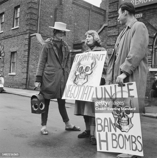 Three protesters stand with the banners 'Unite To Ban H Bombs' and 'It Can't Wait - Negotiate' headlining a painted skull, during the 2nd annual...