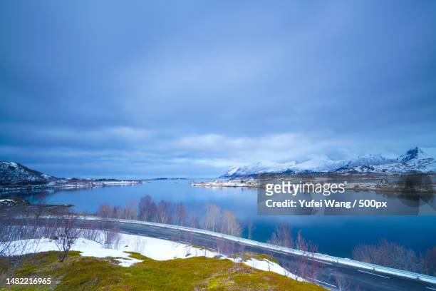 scenic view of lake by snowcapped mountains against sky,hamn,norway - hamn stock pictures, royalty-free photos & images
