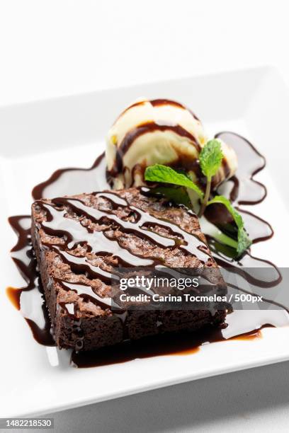 vegan chocolate brownie dessert with dairy-free vanilla ice cream,romania - caramel sauce stock pictures, royalty-free photos & images